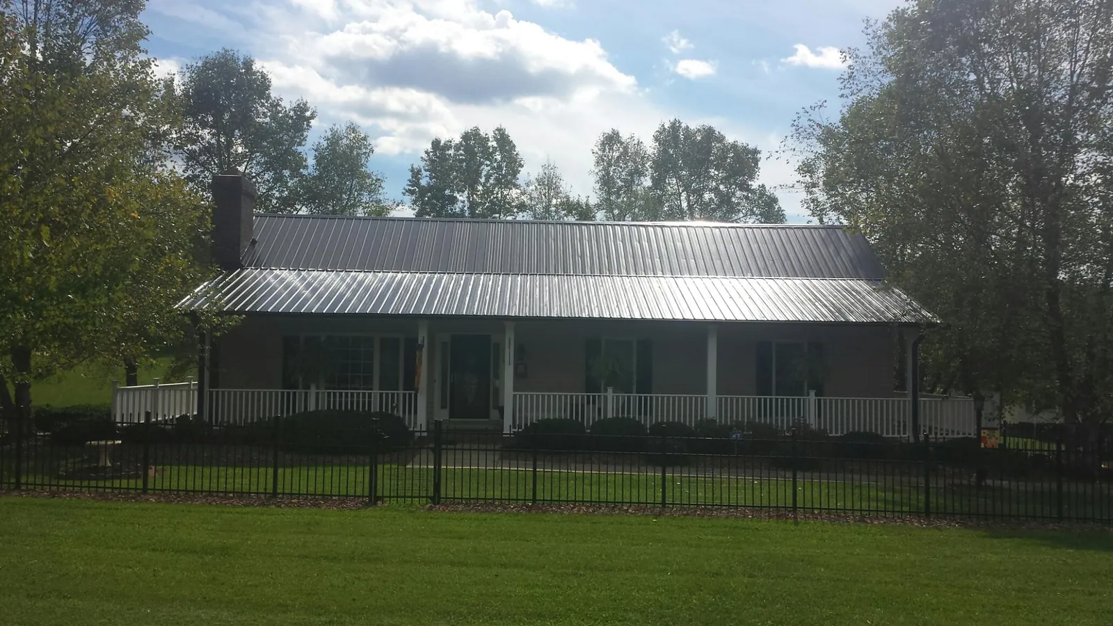 Gray metal roof on a brick ranch with a full width front porch — Gutter Guard Installation work by our crew in Hamburg